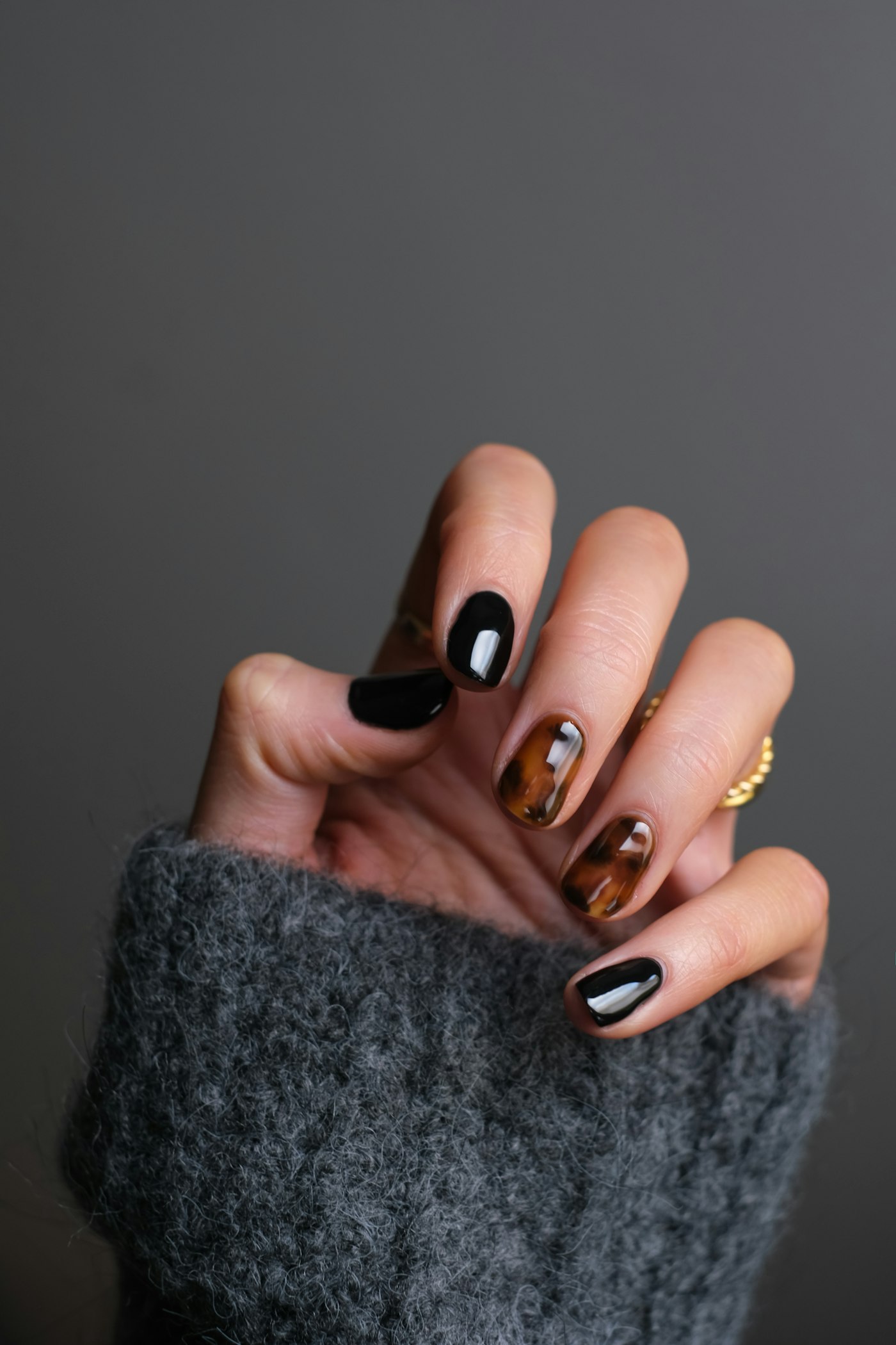 Manicured nails in black and amber polish